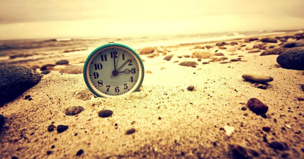 relogio na areia da praia
