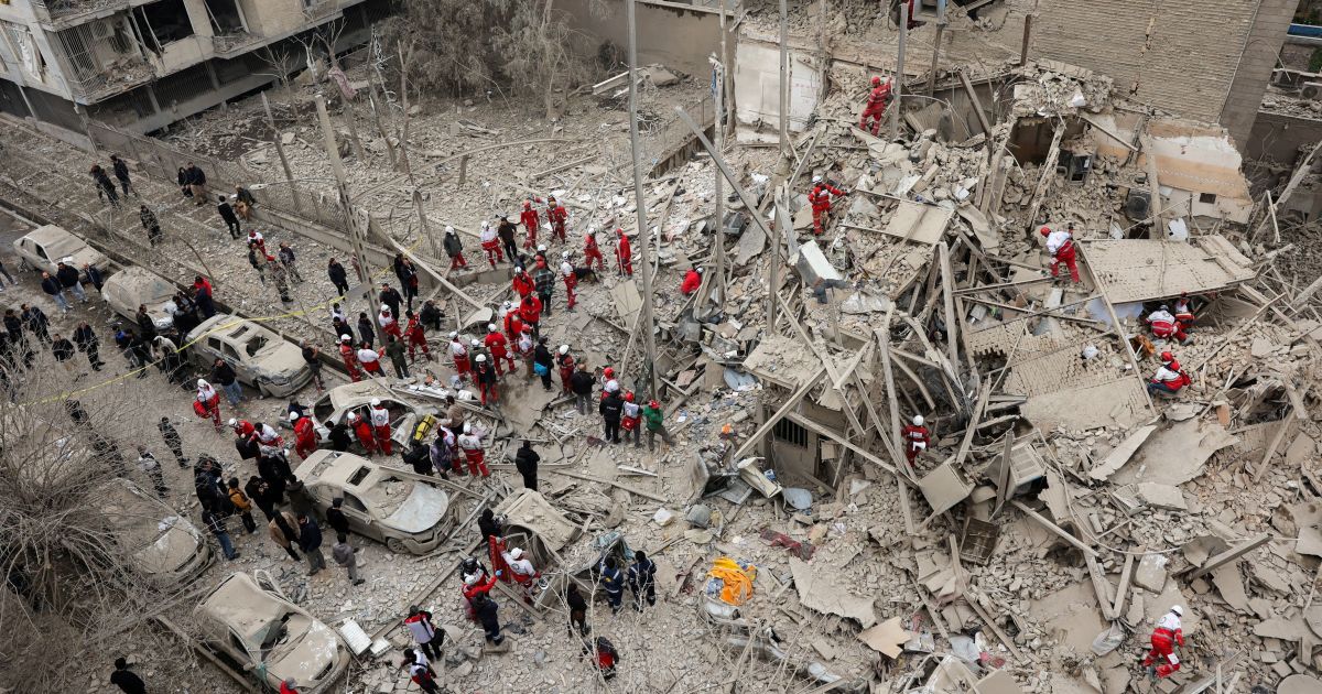 Equipes de resgate trabalham no local de um ataque contra um predio comercial em Teera